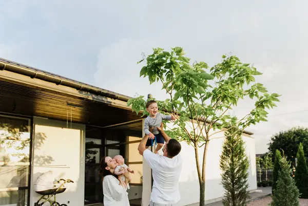 Young family playing in front of their first home