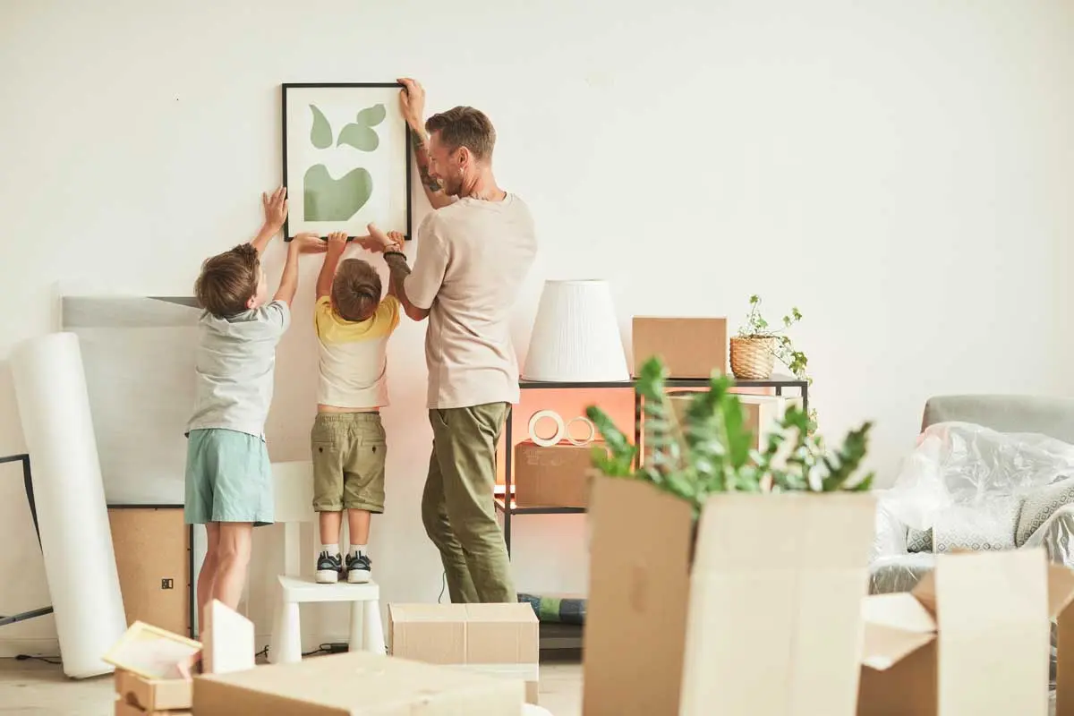 Family hanging artwork while settling into a refreshed home