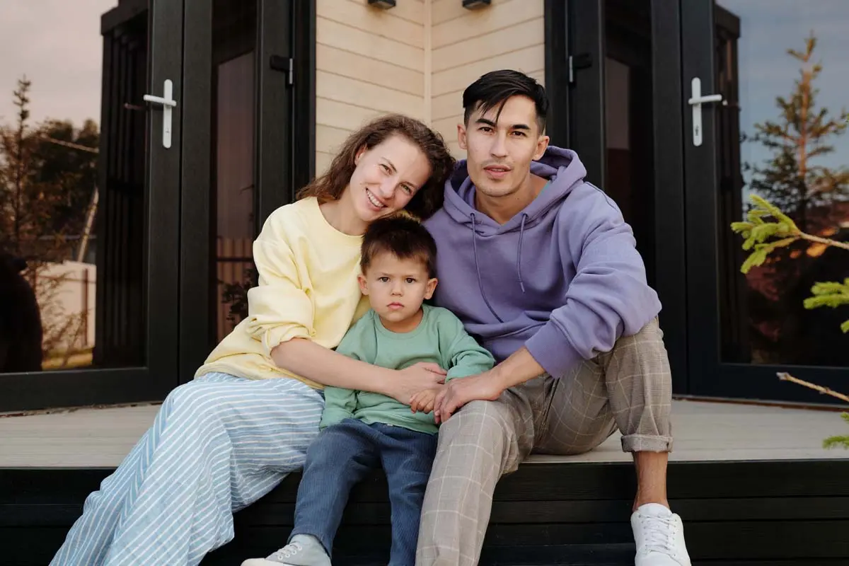 Family sitting together on the front steps of their home