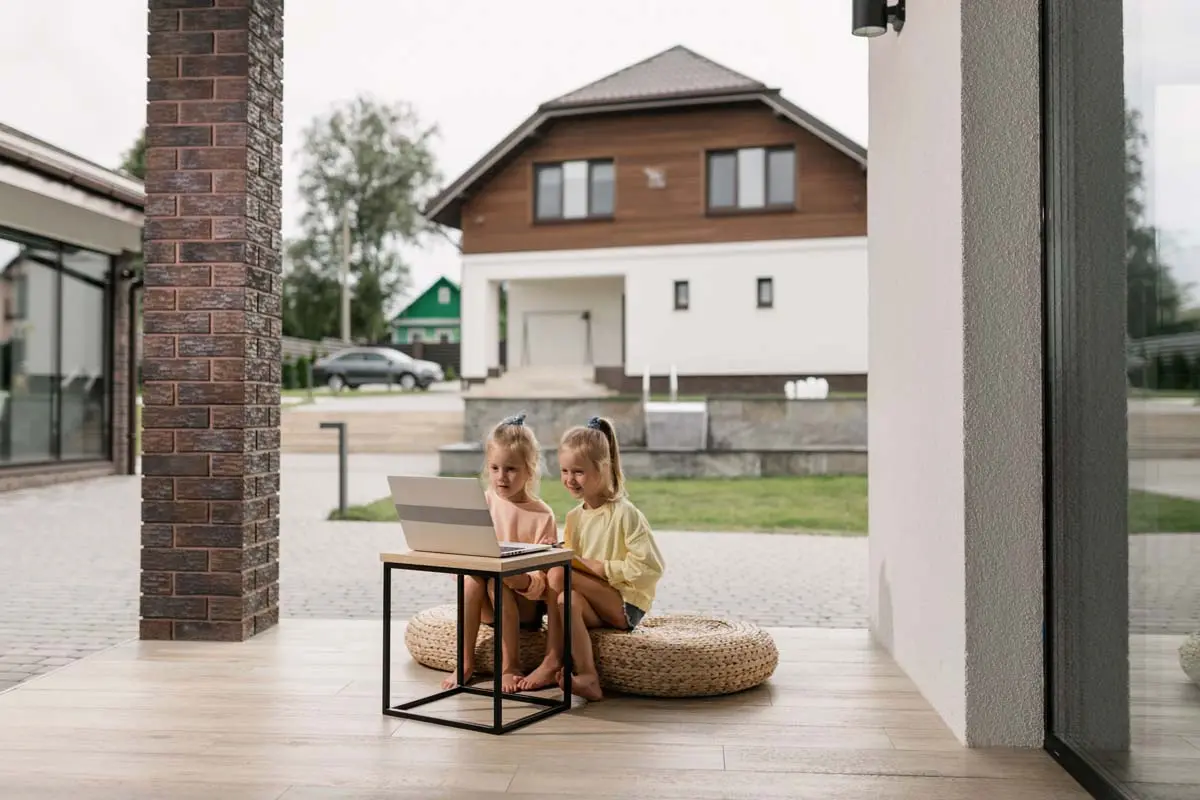 Kids sitting on the front porch of their home