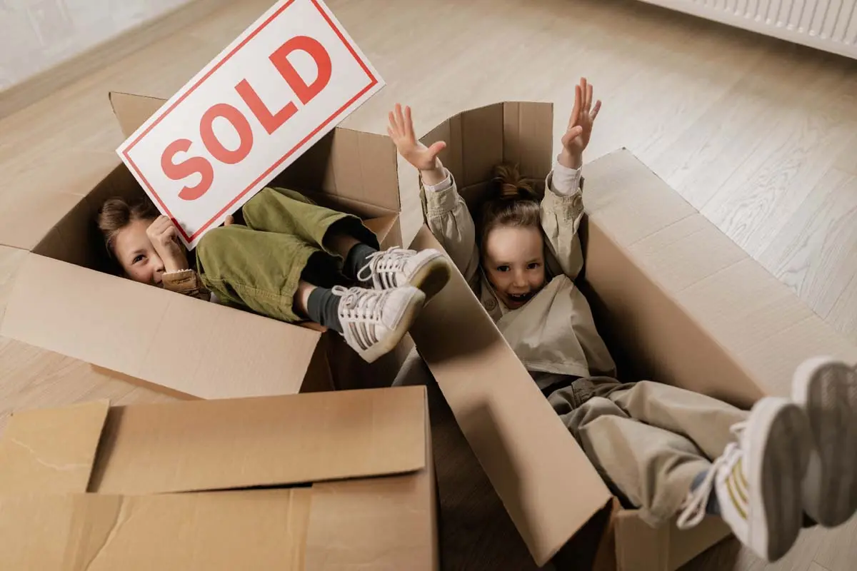 Kids celebrating a sold home with moving boxes