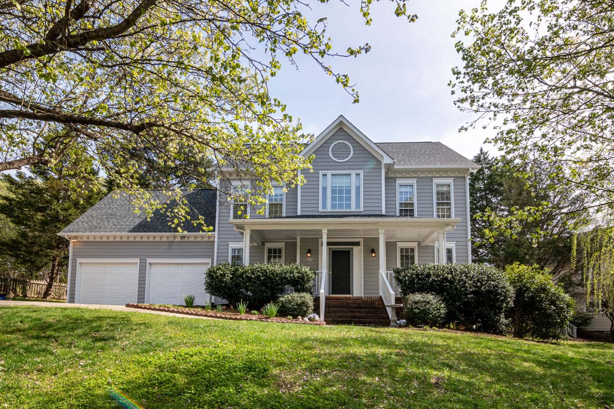 Large grey two-story home with a wide facade